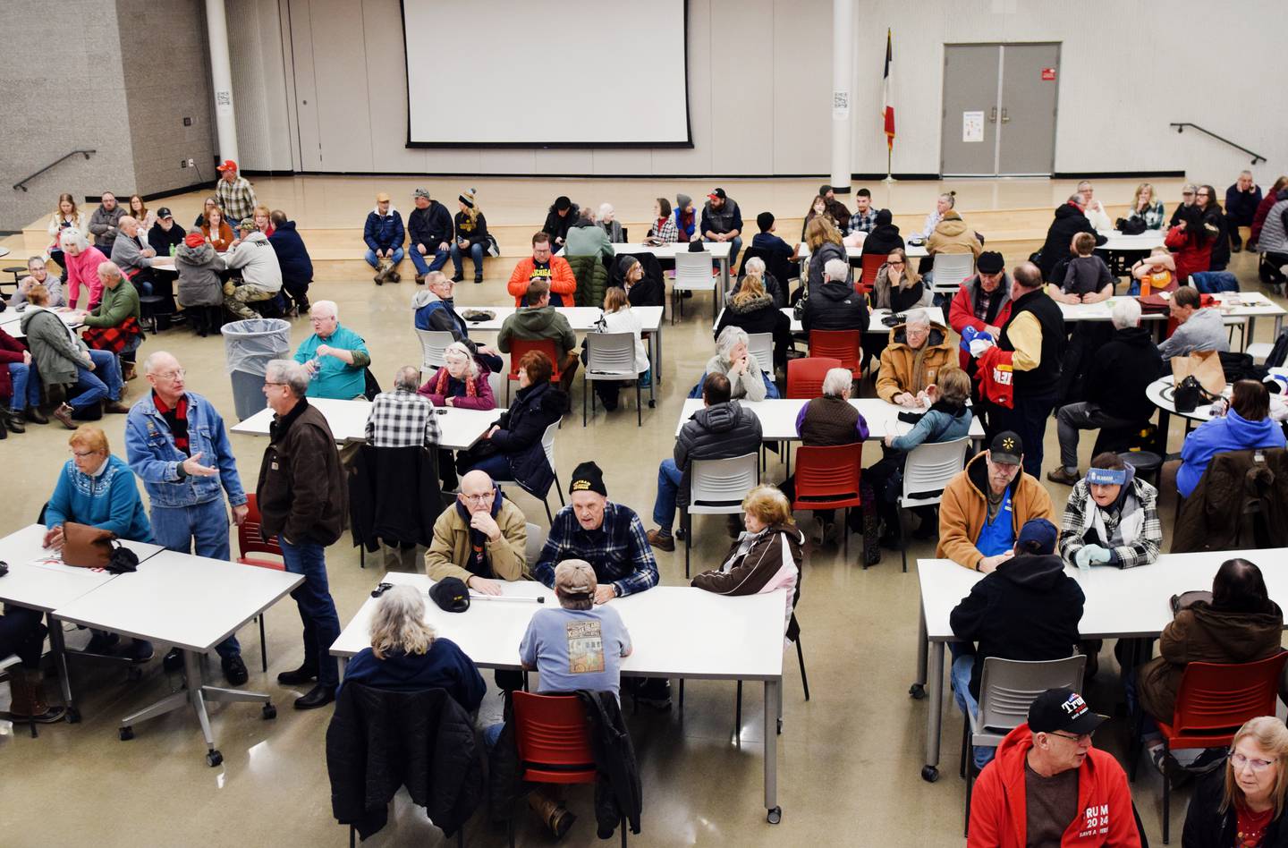 Newton residents gather around tables during caucus night Jan. 15 at Berg Middle School. Despite frigid temperatures and overwhelming snowfall, residents showed up in droves to participate in the caucuses, which were overwhelmingly in support of former president Donald Trump in Jasper County and throughout the state.