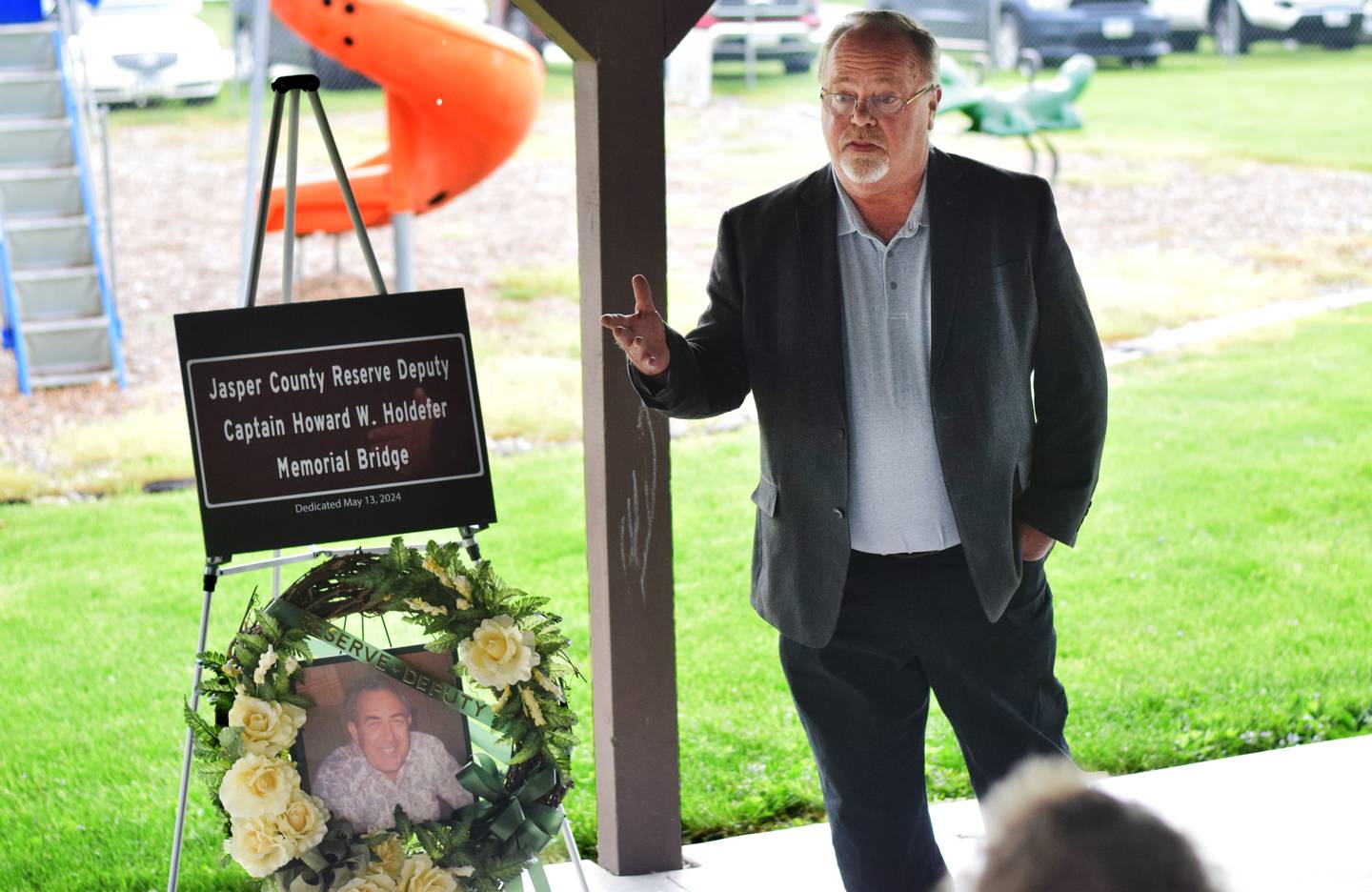 Supervisor Denny Stevenson speaks to Howard Holdefer's family during a dedication ceremony May 13 at the city park in Reasnor.