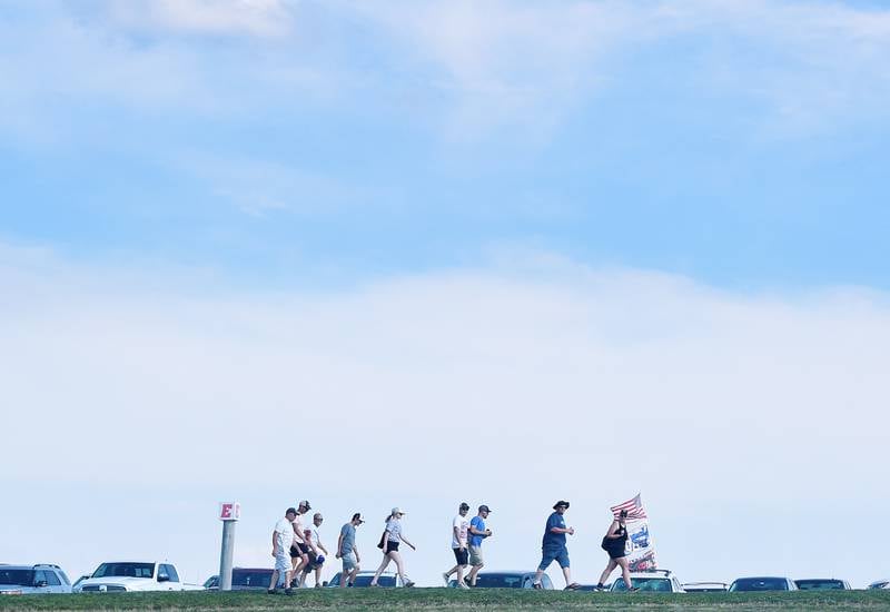 After finding a parking spot, spectators make their way to the grandstands to watch the NASCAR Cup Series Iowa Corn 350 race on June 16 at the Iowa Speedway in Newton