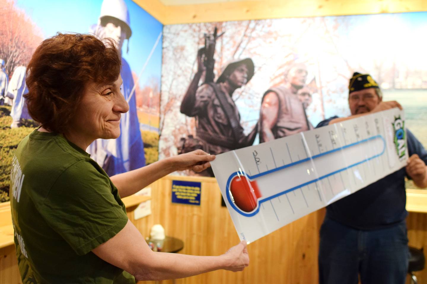 From left: Mady McKim and Jerry Nelson hold the fundraiser thermometer at the American Legion Post 111 in Newton. McKim, the historian and social media manager, said a number of fundraisers will be held in the coming months to repair the post’s roof and parking lot. Nelson, the post commander, said the goal is to raise $60,000.