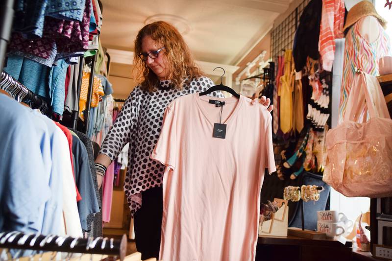 Dawn Peters, owner of Next Chapter Boutique, showcases merchandise during her store's grand opening April 15 in downtown Newton.