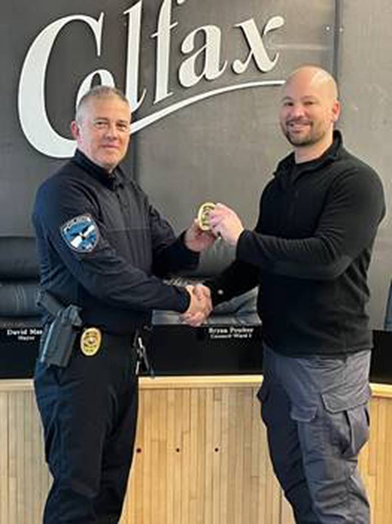 Chief Burdess congratulates Officer Will Mortensen