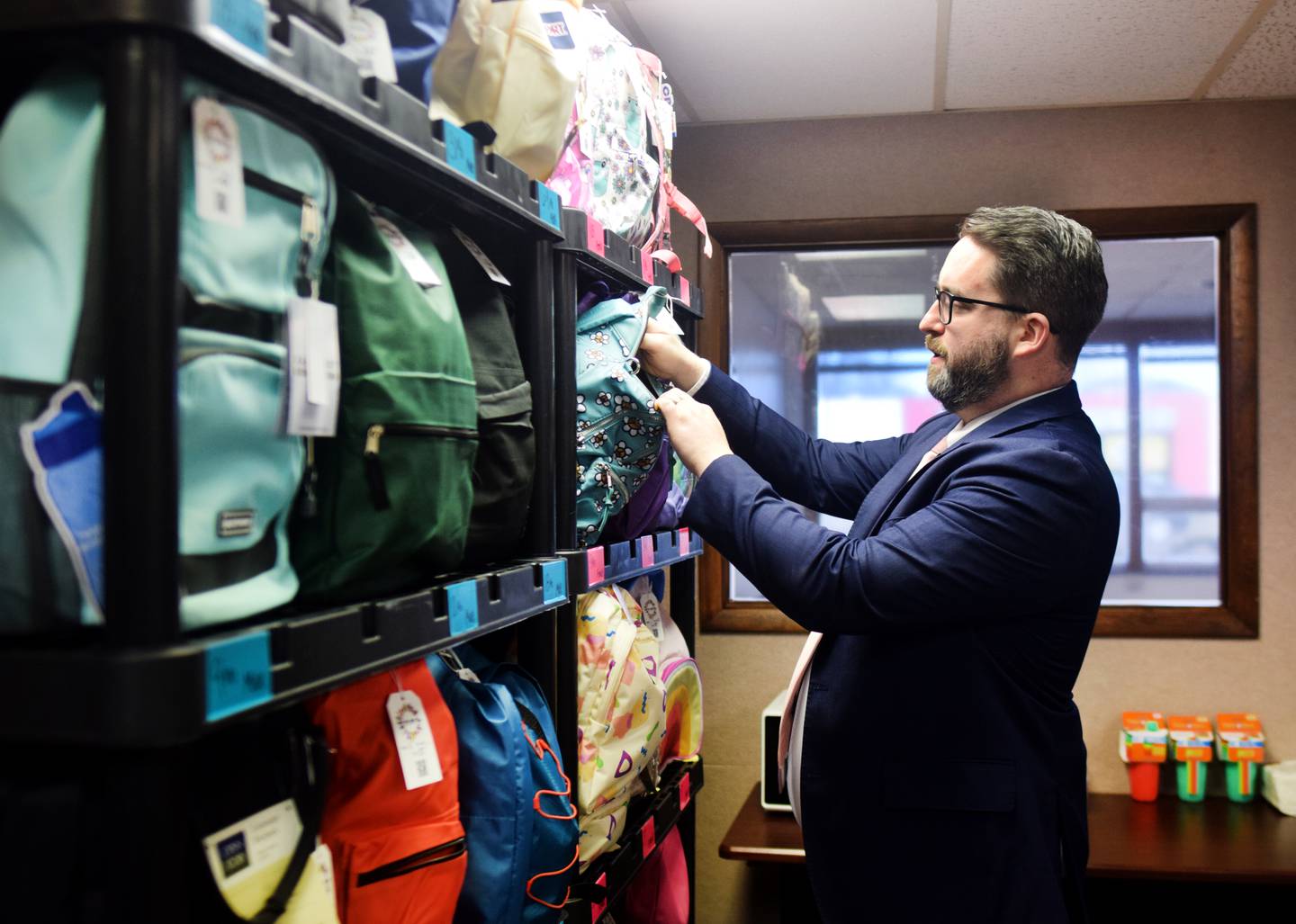 Nicholas Pietrack, assistant county attorney and founder of the Open Arms Foundation Jasper County, shows off the First Night Backpacks by the newly established nonprofit, which aims to improve the lives of children in foster care and those who had to be removed from families due to abuse.