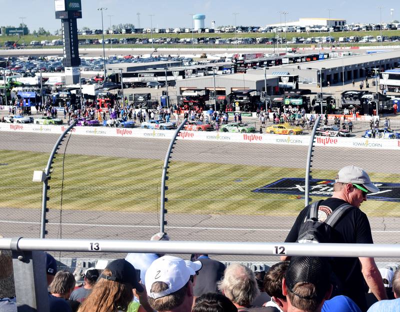 While drivers line up for the race to start, a spectator looks for his seat at the NASCAR Cup Series Iowa Corn 350 race June 16 at the Iowa Speedway in Newton.