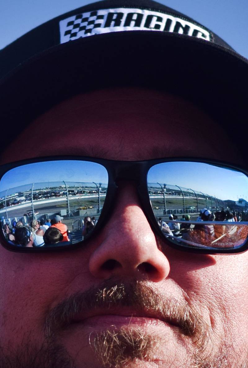 The NASCAR Cup Series Iowa Corn 350 race can be seen from the reflection of onlooker Scott Jerrett's sunglasses on June 16 at the Iowa Speedway in Newton.