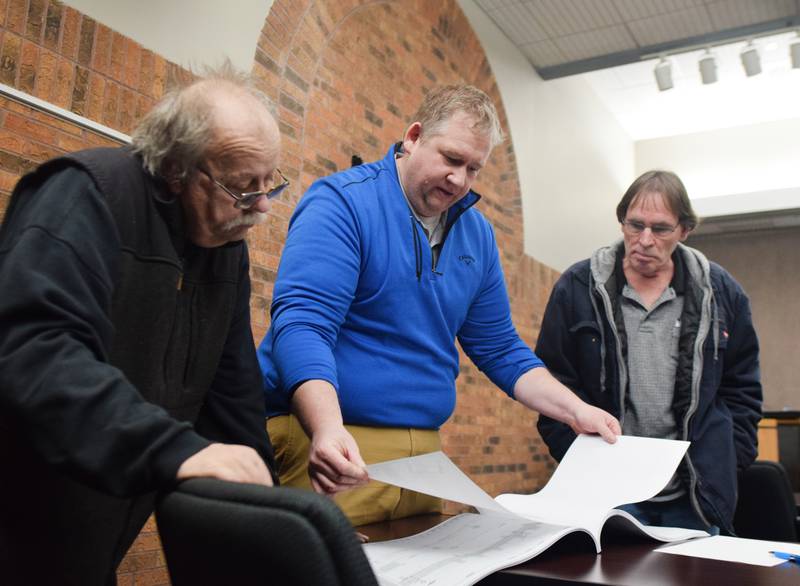 Newton Public Works Director Joe Grife, center, looks through the Union Drive project plans with residents during an open house on March 2 inside the council chambers of city hall.