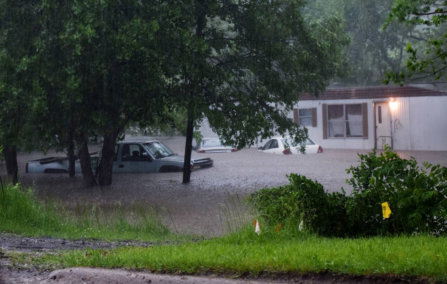 Vehicles and a home in Lambs Grove on May 21 are almost completely submerged in floodwater. Several communities in Jasper County were affected by the floods after a full night of heavy rainfall and even more sporadic downpours the next day.